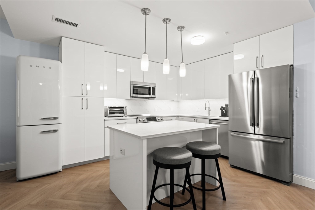 771 Harrison Avenue, Unit 206 Boston, MA 02118 - Photo 1 of 22 a kitchen with stainless steel appliances a refrigerator a stove a sink and white appliances