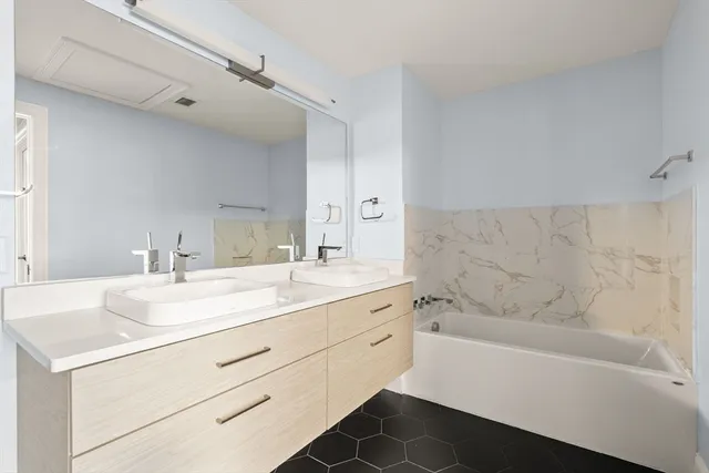 a bathroom with a bathtub sink vanity granite and a mirror