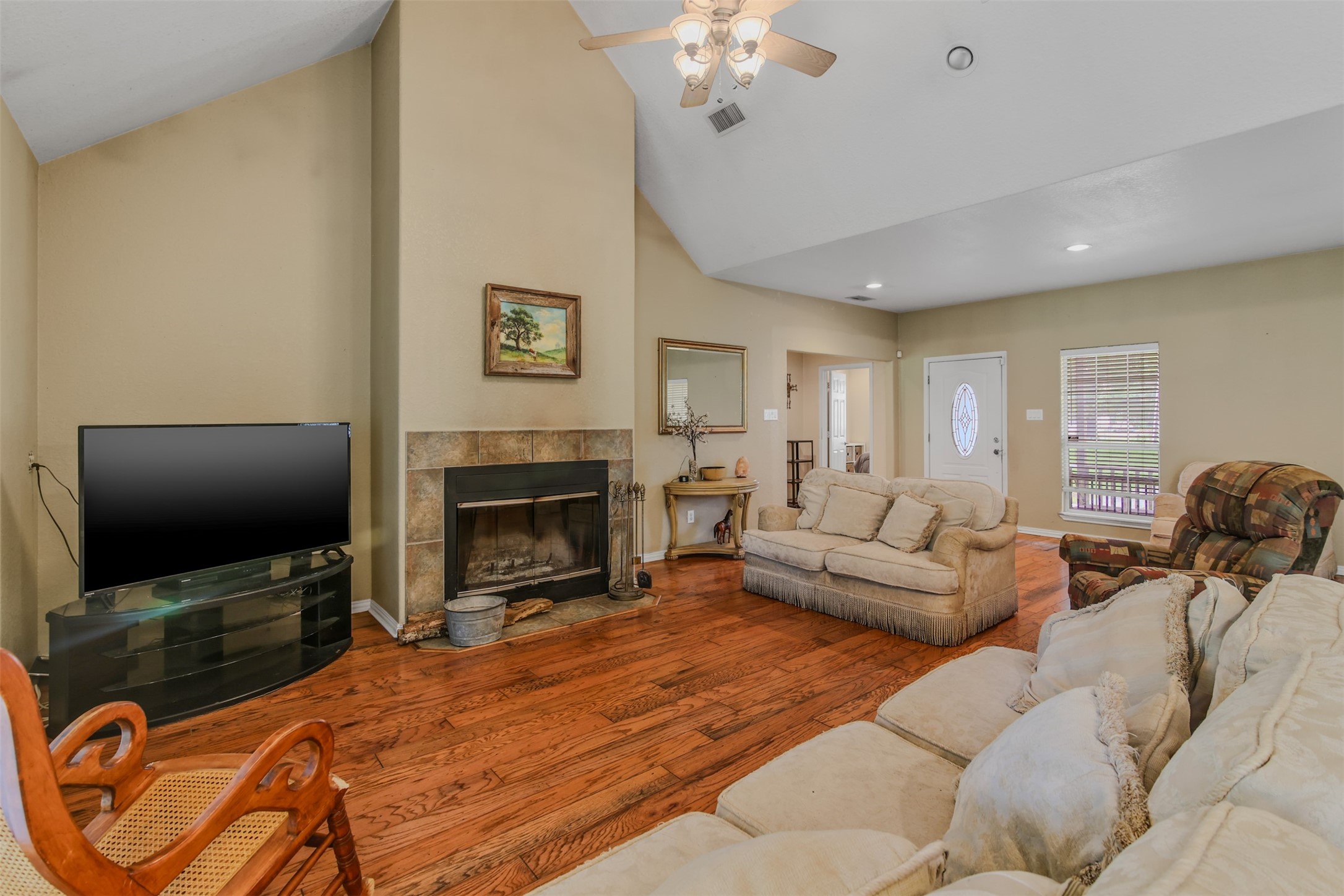 11692 Clark Lane Conroe, TX 77385 - Photo 3 of 35 The spacious family room features hardwood floors, architectural ceiling, fan and wood burning fireplace with tile surround.