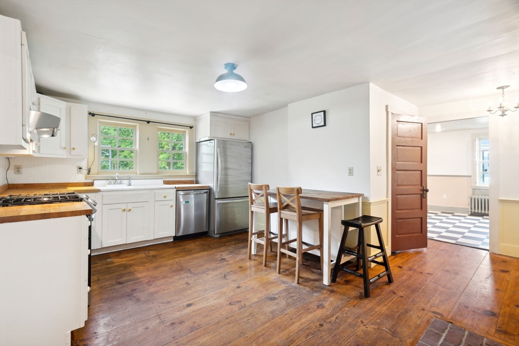 409 Main Street Townsend, MA 01474 - Photo 9 of 35 a kitchen with a table chairs a sink dishwasher window and cabinets