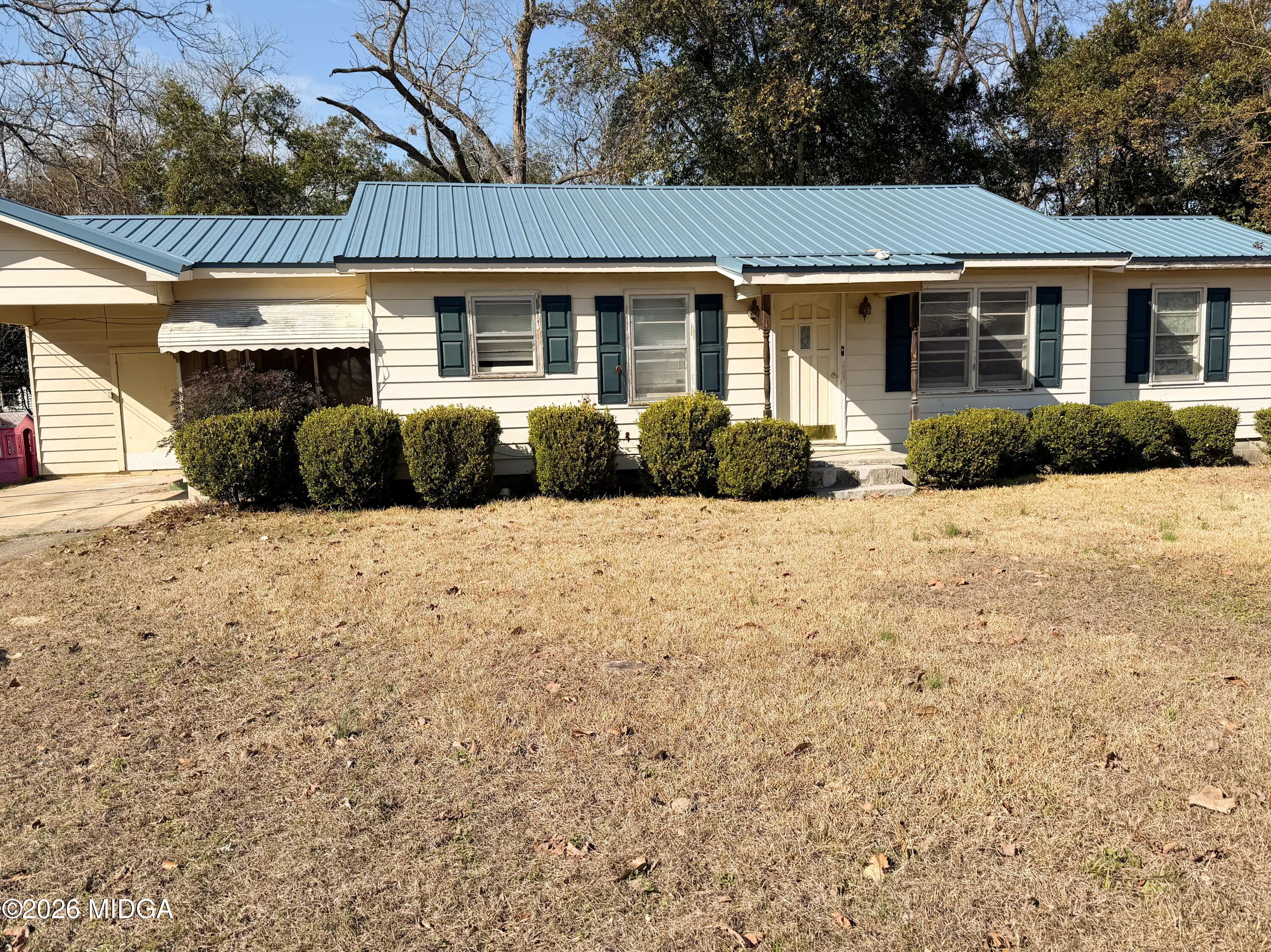 a front view of a house with a yard covered with trees