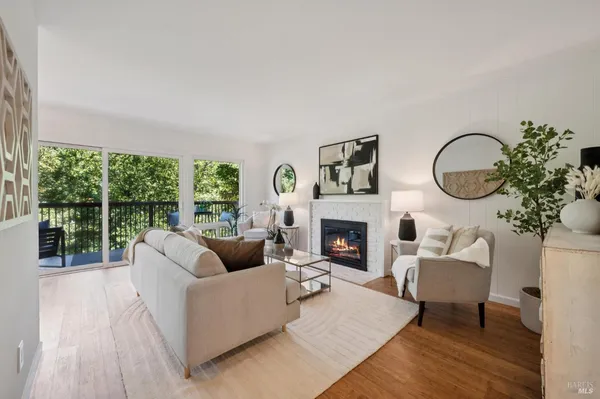 a living room with furniture a fireplace and a floor to ceiling window