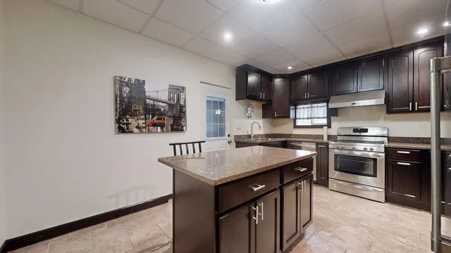 a kitchen with kitchen island a sink stove and refrigerator