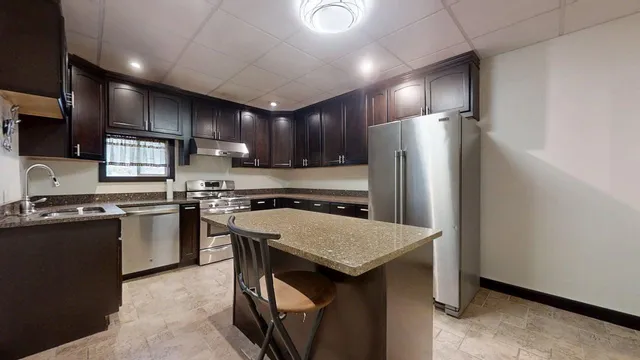 a kitchen with stainless steel appliances granite countertop a stove a refrigerator and a oven