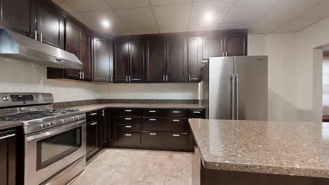 a kitchen with granite countertop a sink and a stove