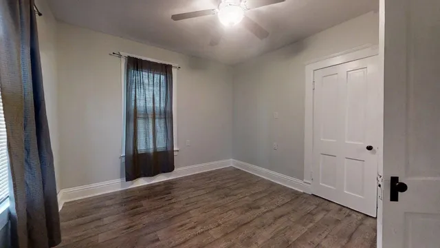 an empty room with wooden floor and a window