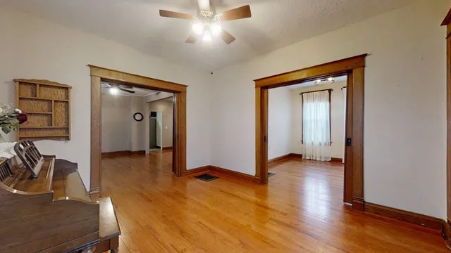 a view of a livingroom with wooden floor and a ceiling fan