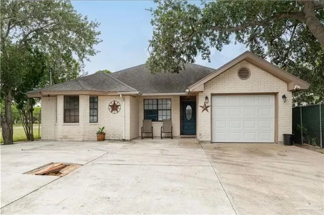 a front view of a house with a garden and trees