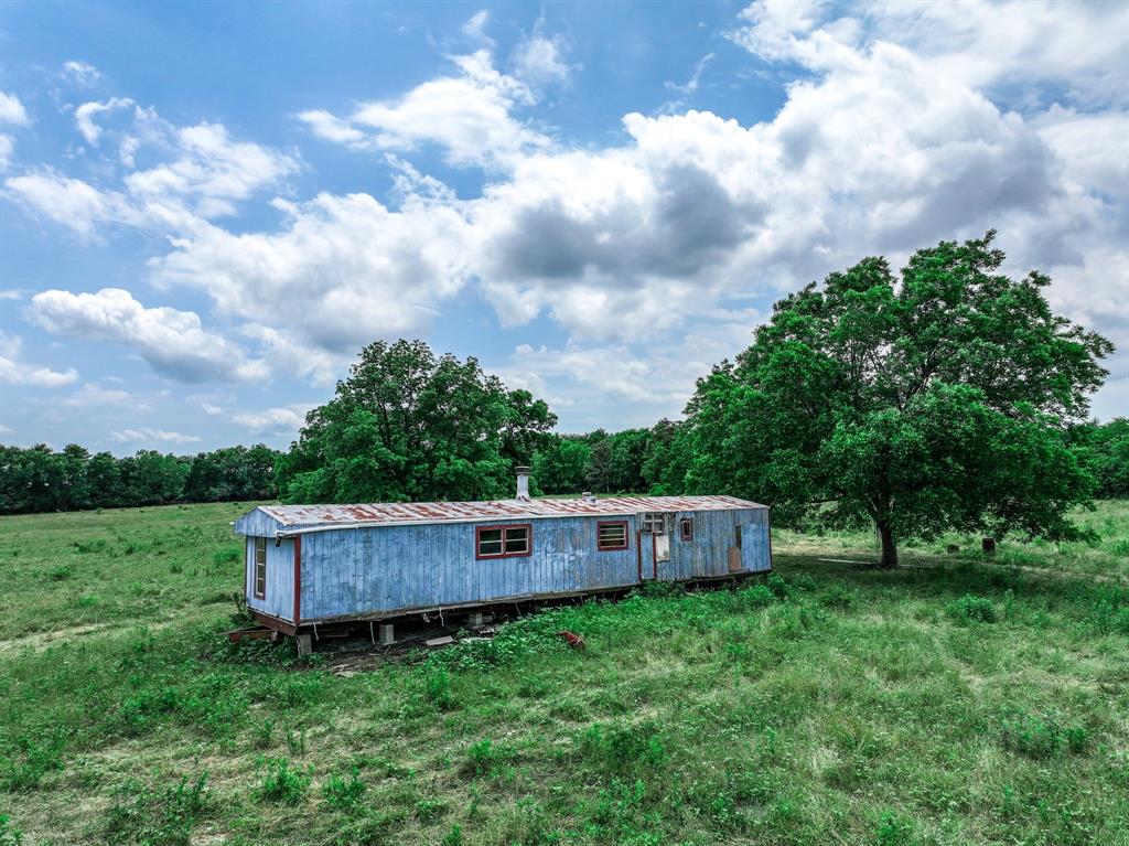 2190 County Road 2190 Commerce, TX 75428 - Photo 28 of 35 a backyard of a house with lots of green space and wooden fence