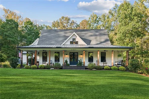 a front view of a house with a garden and trees