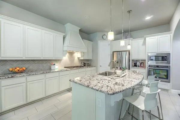 a kitchen with kitchen island granite countertop a table and chairs in it