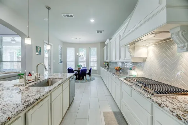 a kitchen with sink stove and cabinets