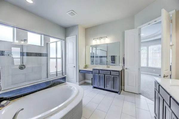 a bathroom with a tub sink and mirror