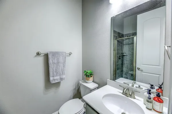 a bathroom with a sink vanity mirror and toilet