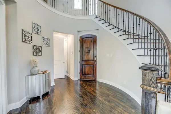a view of front door with wooden floor and stairs