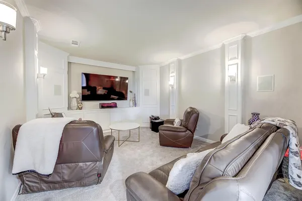 a living room with furniture a flat screen tv and kitchen view