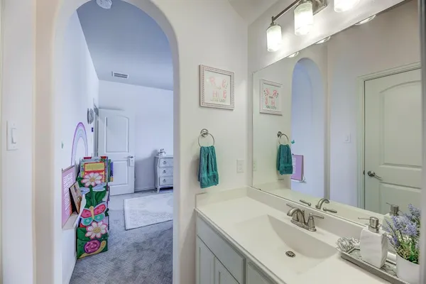 a bathroom with a sink mirror and vanity