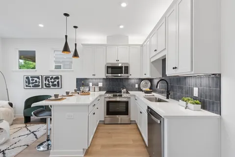 a kitchen with granite countertop white cabinets and white appliances