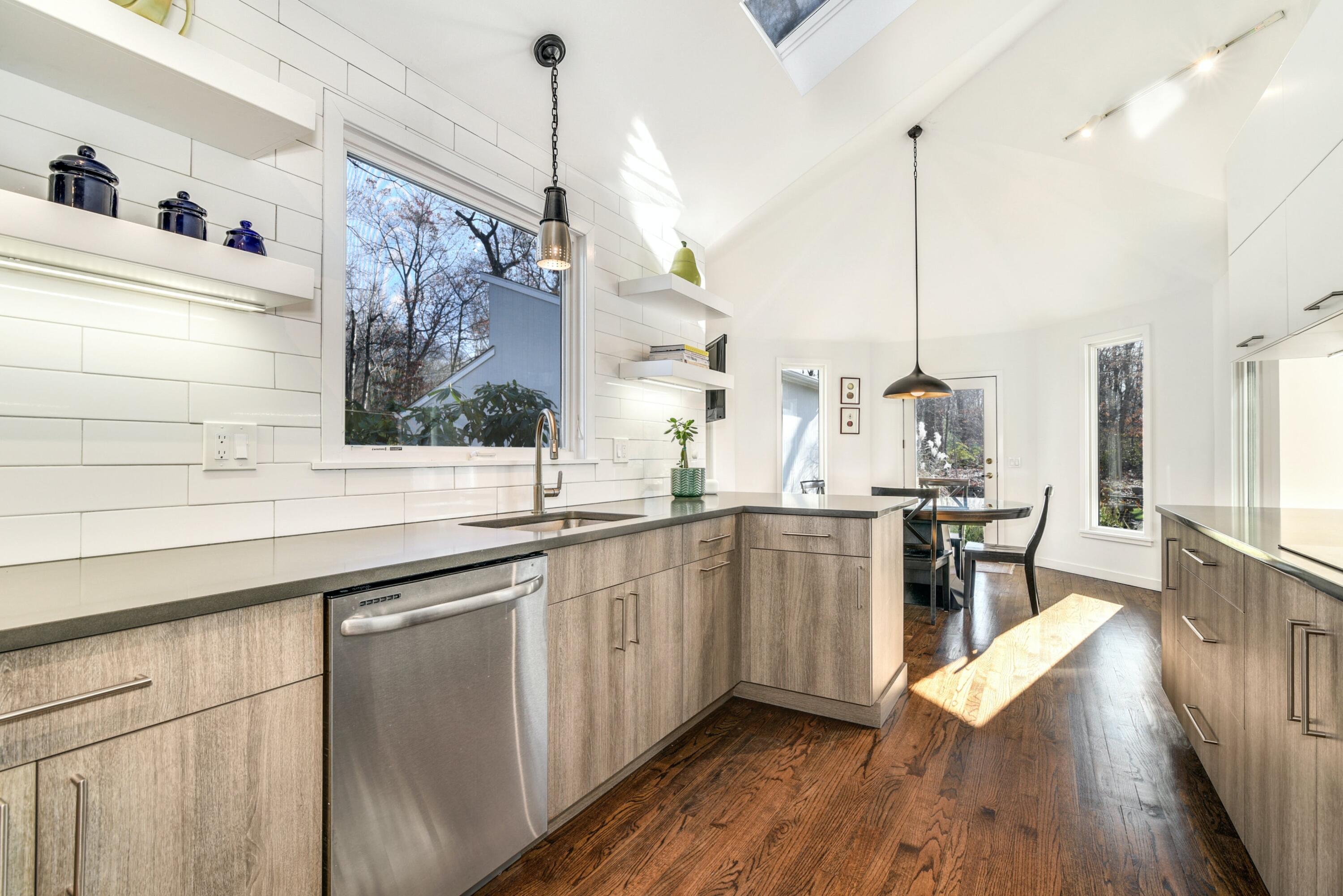 612 Laurel Road New Canaan, CT 06840 - Photo 14 of 40 a kitchen with stainless steel appliances granite countertop a sink a stove and a wooden floor