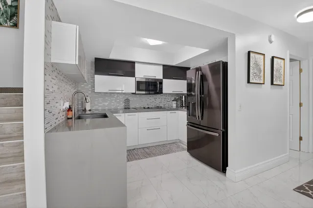 a kitchen with stainless steel appliances granite countertop a refrigerator and a stove
