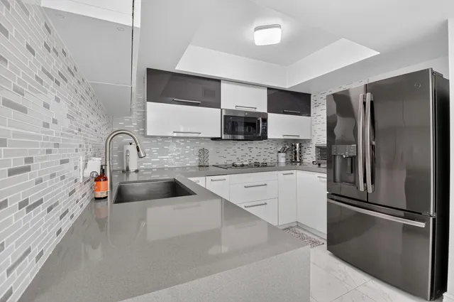 a view of a kitchen with a sink and refrigerator
