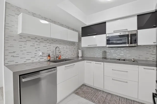a kitchen with stainless steel appliances granite countertop a sink and a stove
