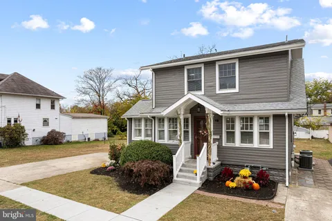 a front view of a house with lots of trees and plants