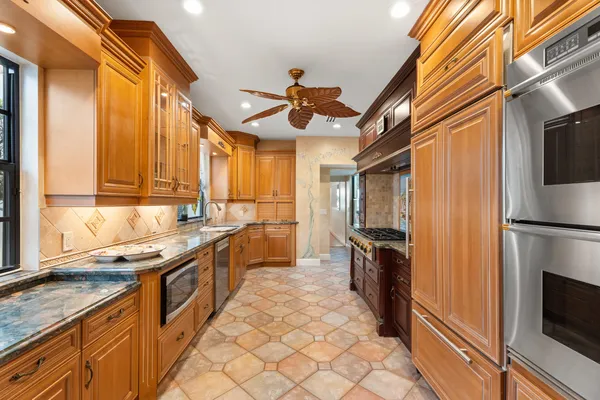 a kitchen with granite countertop a sink stainless steel appliances and cabinets