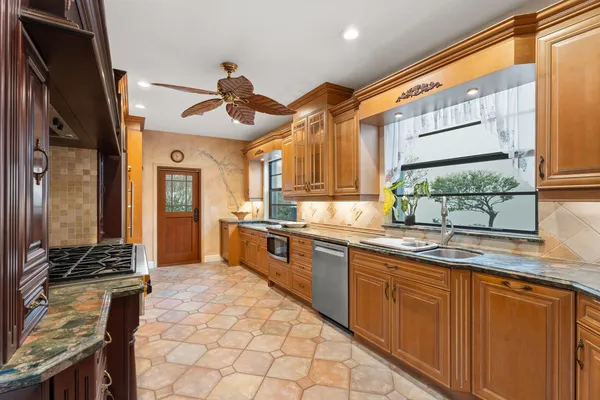 a kitchen with stainless steel appliances granite countertop a sink and cabinets