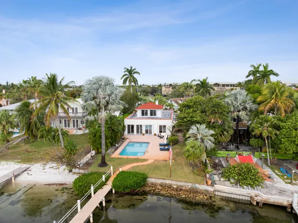 a view of a house with a yard and potted plants