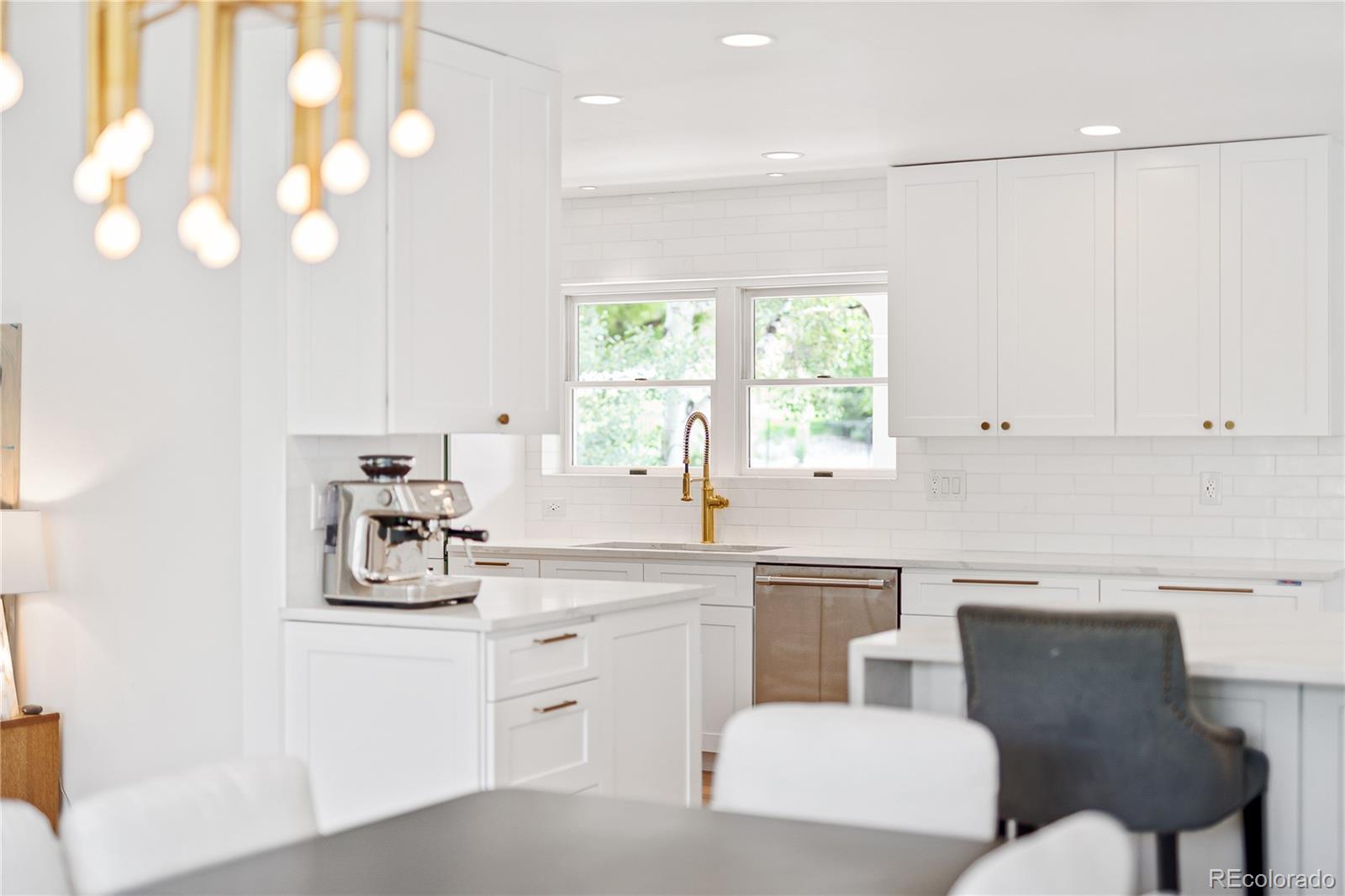 1 Hillside Drive Wheat Ridge, CO 80215 - Photo 17 of 50 a kitchen with stainless steel appliances a white cabinets and a chandelier