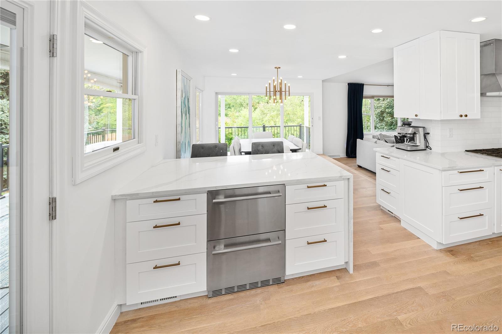 1 Hillside Drive Wheat Ridge, CO 80215 - Photo 19 of 50 a kitchen with stainless steel appliances kitchen island granite countertop a stove a sink and a refrigerator