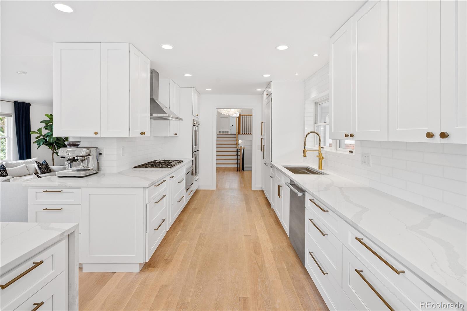1 Hillside Drive Wheat Ridge, CO 80215 - Photo 20 of 50 a large kitchen with stainless steel appliances sink a stove and white cabinets