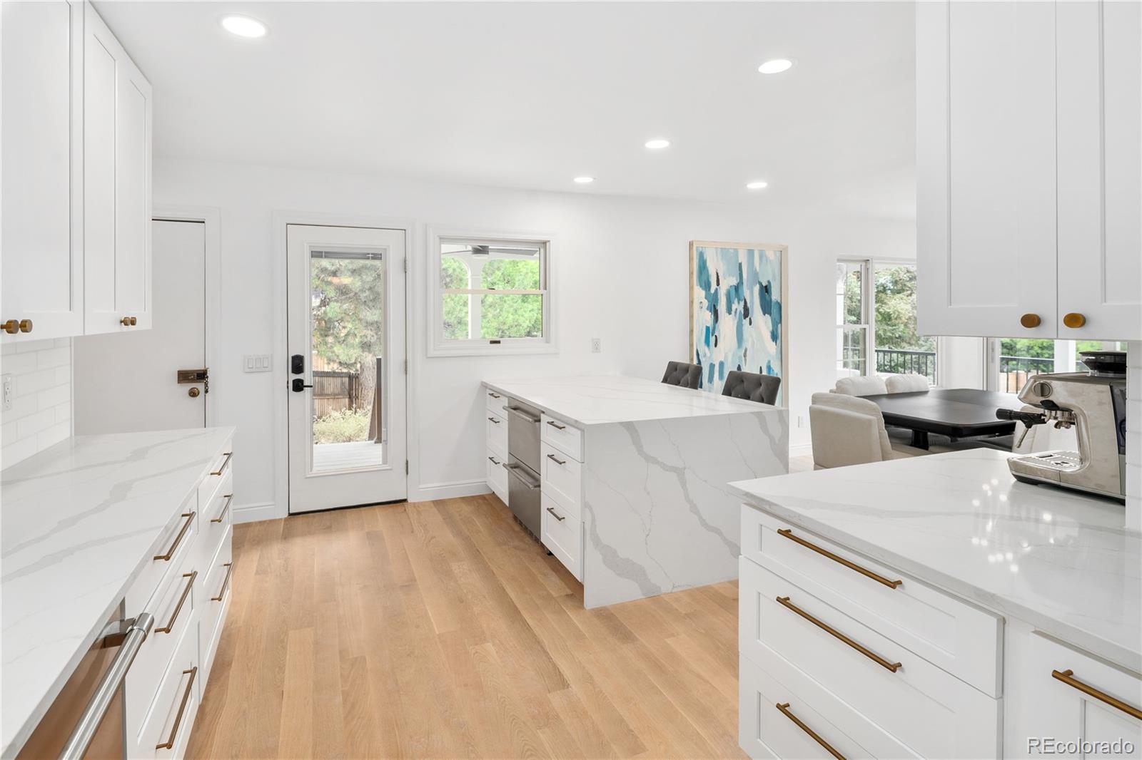 1 Hillside Drive Wheat Ridge, CO 80215 - Photo 21 of 50 a view of a kitchen with kitchen island a sink wooden floor and a large window