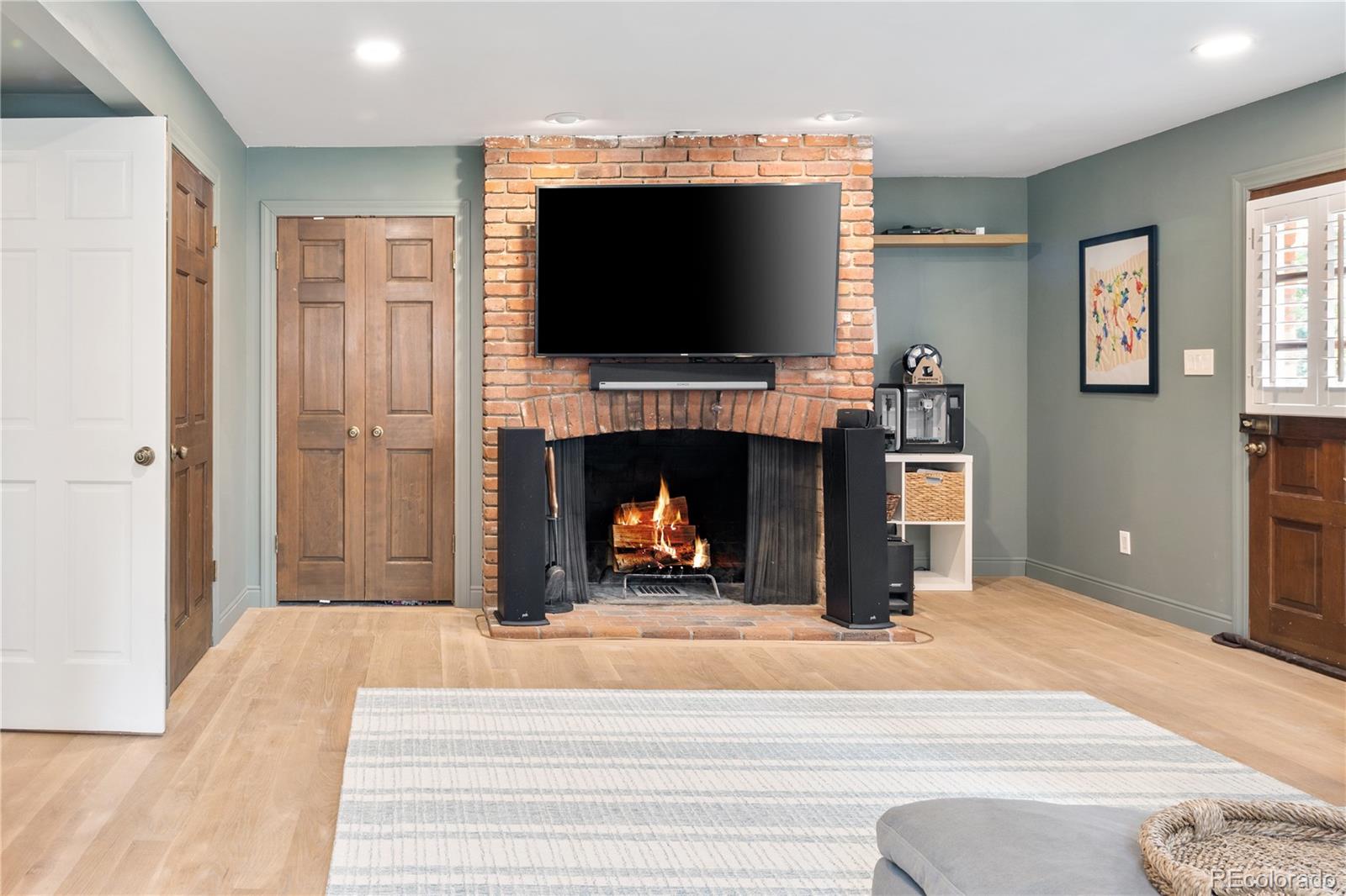 1 Hillside Drive Wheat Ridge, CO 80215 - Photo 36 of 50 a living room with a fireplace and a flat screen tv