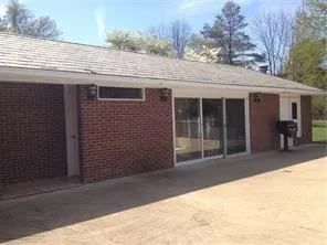 a view of house with backyard and glass windows
