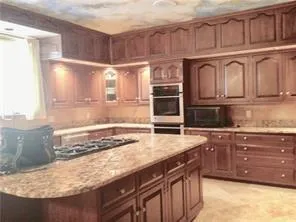 a kitchen with stainless steel appliances granite countertop a sink and cabinets
