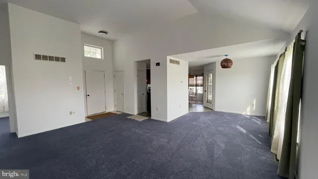 an empty room with closet and windows