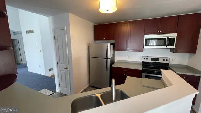 a kitchen with stainless steel appliances granite countertop a refrigerator and a stove top oven