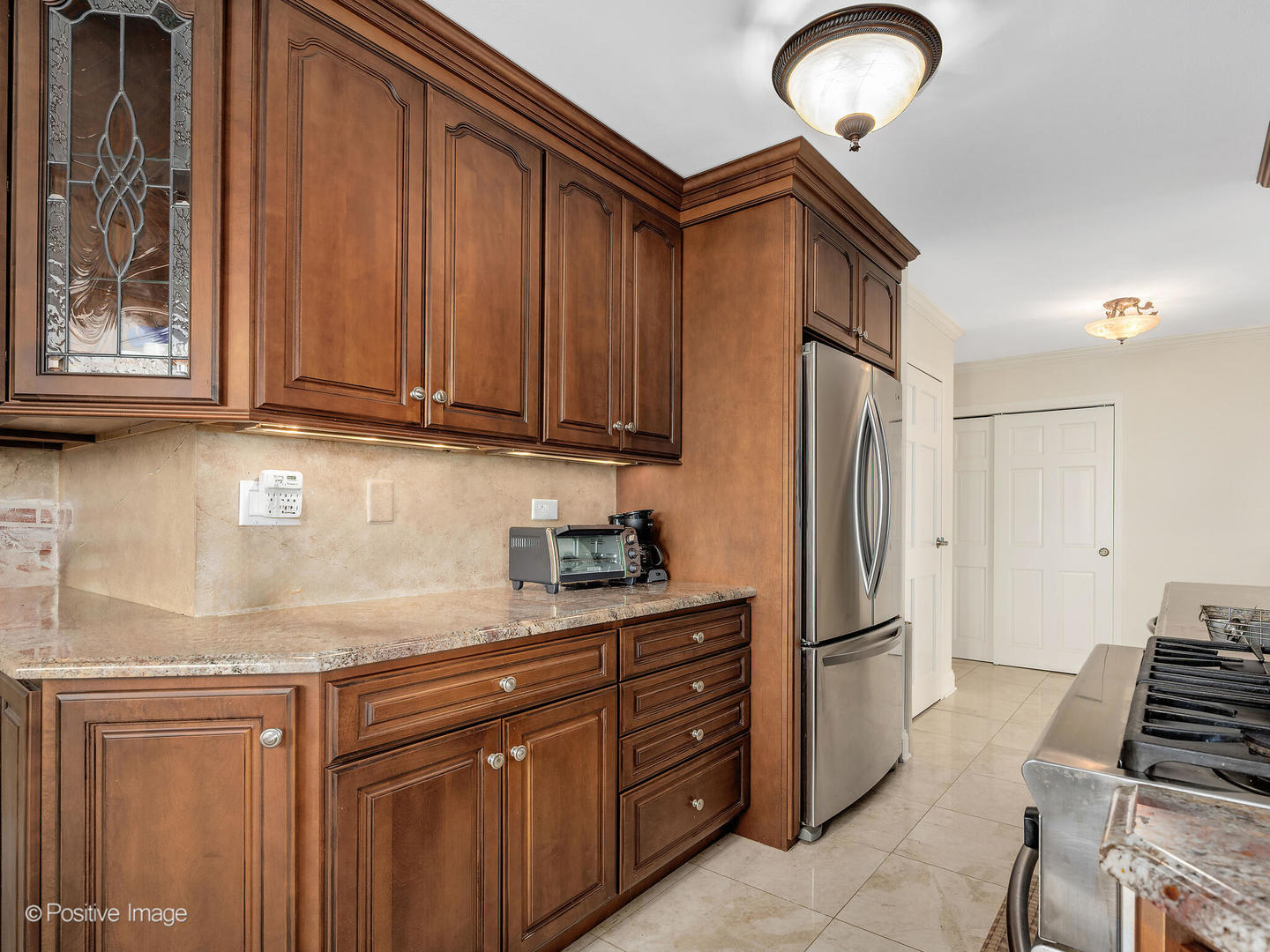 40 North Tower Road, Unit 12F Oak Brook, IL 60523 - Photo 9 of 25 a kitchen with stainless steel appliances granite countertop a refrigerator and a stove top oven