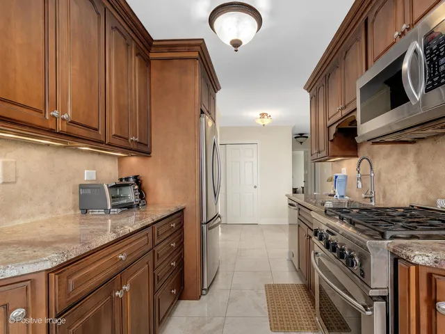 a kitchen with stainless steel appliances granite countertop a stove and a microwave