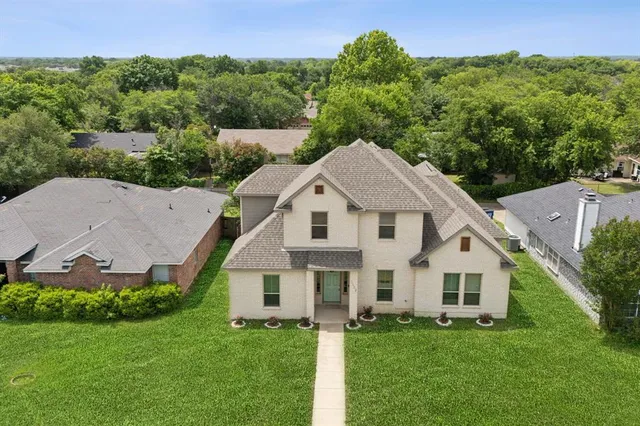 an aerial view of residential house with outdoor space and trees all around