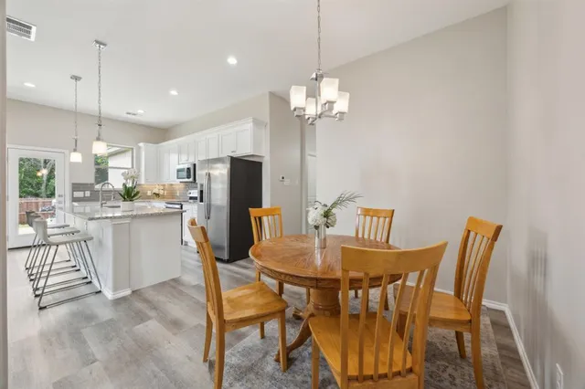 a view of a dining room with furniture and a chandelier