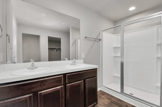 a bathroom with a sink shower and a mirror