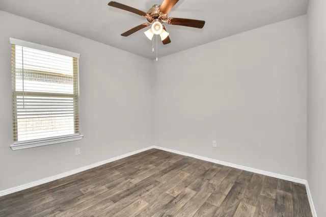 wooden floor in an empty room with a window