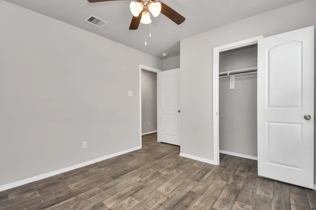 a view of an empty room with wooden floor