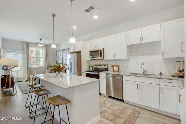 a kitchen with stainless steel appliances kitchen island granite countertop a sink and cabinets