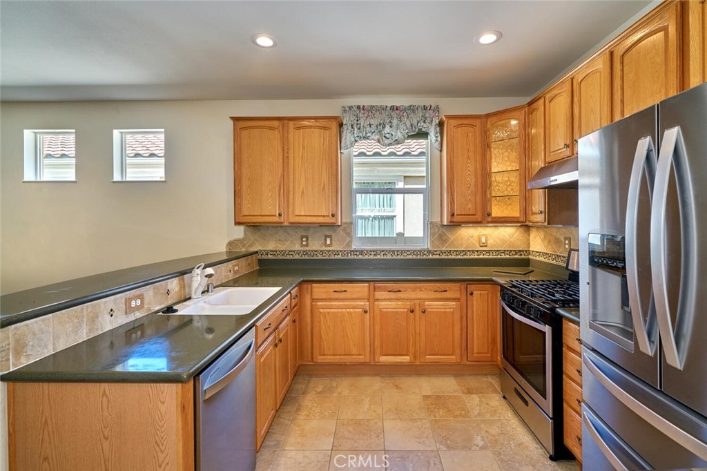 1143 Saguara Road Beaumont, CA 92223 - Photo 40 of 66 a kitchen with stainless steel appliances granite countertop a sink stove and refrigerator
