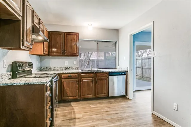a kitchen with stainless steel appliances granite countertop a stove a sink and a refrigerator