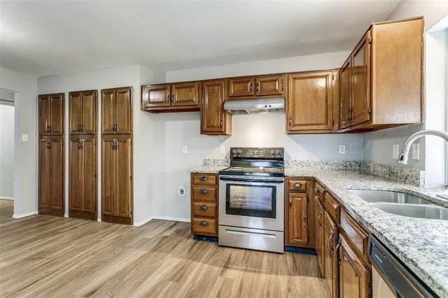 a kitchen with stainless steel appliances granite countertop a sink stove and refrigerator